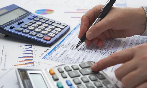 Man using calculator at AlZarooni & Associates.