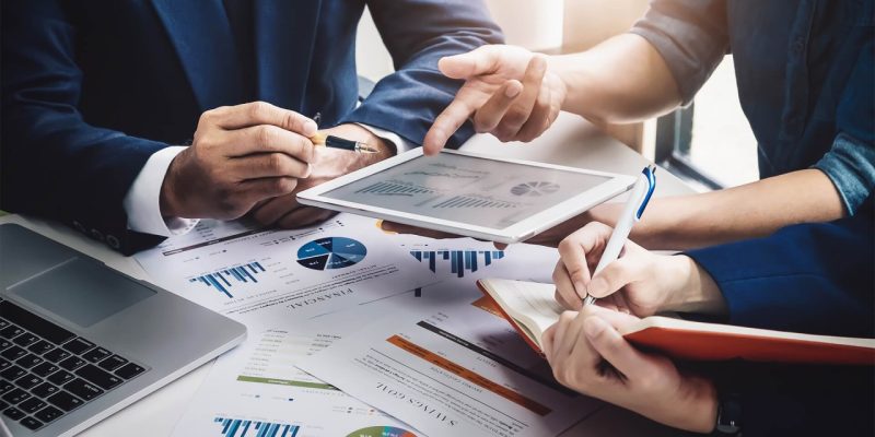 1684228458886 Business team reviewing documents at AlZarooni & Associates in Dubai.